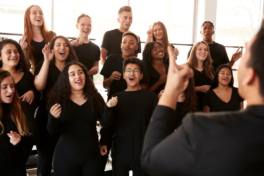 Male and Female Students Singing in Choir with Teacher at Perfor